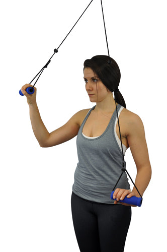 Woman in gray tank top using resistance band with blue handles for upper body exercise against white background