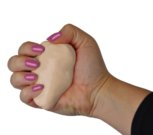 Hand with mauve nail polish squeezing a beige stress relief clay against a white background