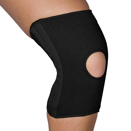 Black knitted knee support sleeve with reinforced panel and open patella design on a bent leg against white background