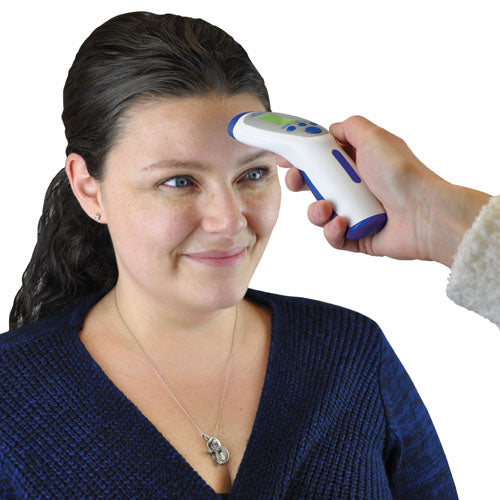 Person having forehead temperature checked using white and blue digital infrared thermometer with green display