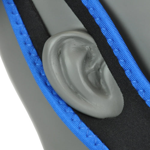 Close-up of blue and black padded strap resting over gray mannequin ear against plain background