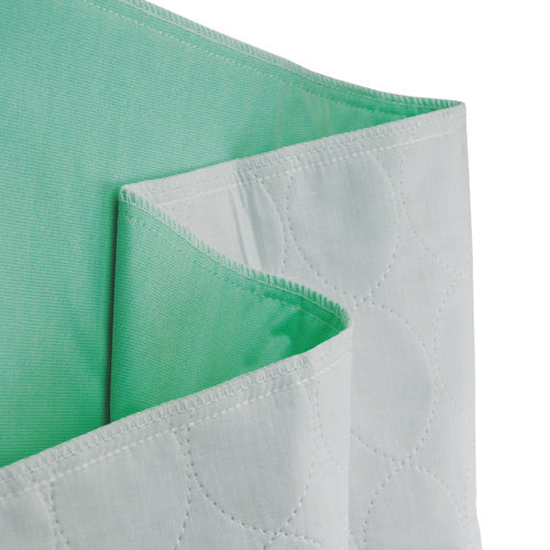 Folded white quilted underpad with smooth light green waterproof backing against white background